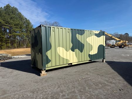 A shipping container custom painted with a a camo pattern.