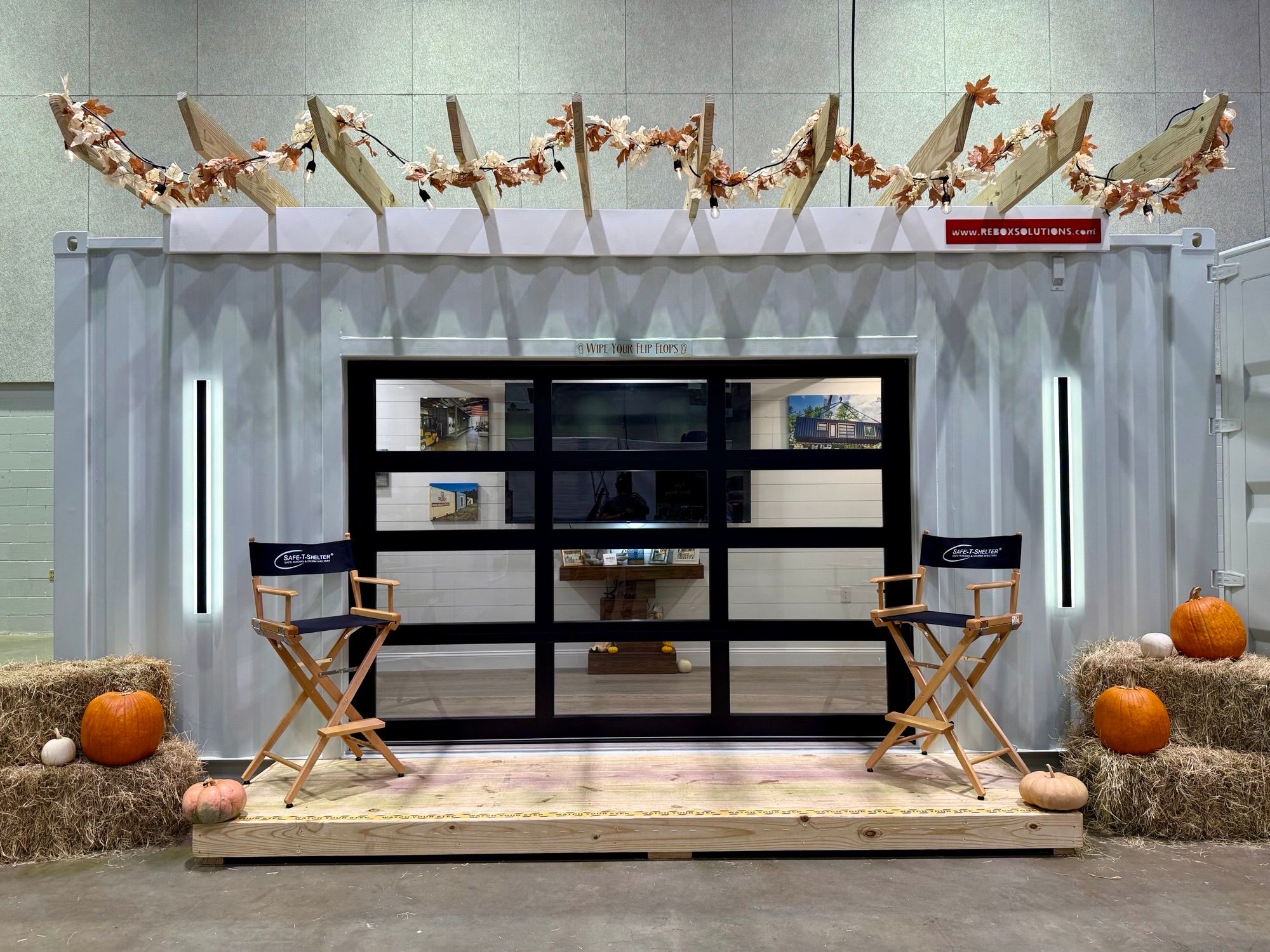 A custom 20' Rebox container cabin with a kitchenette and large roll-up and sliding glass doors.