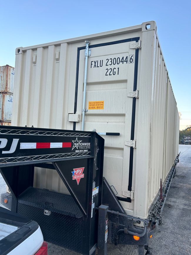 A shipping container with a custom, half width door on one end.