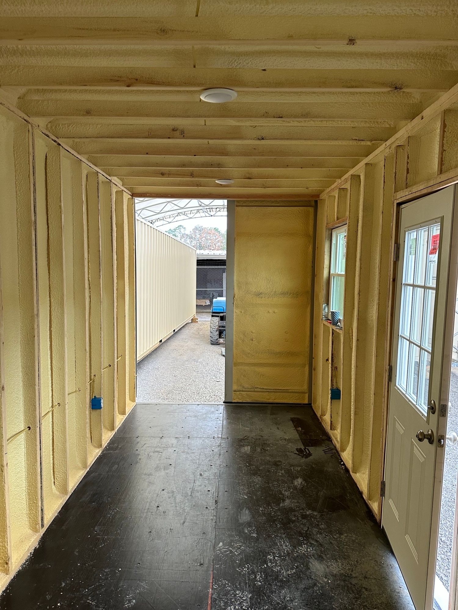 The interior of a container showing the application of high-performance spray foam insulation.